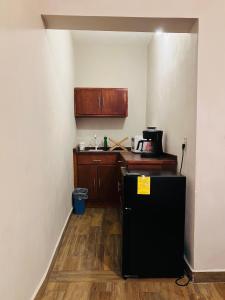 eine kleine Küche mit schwarzem Kühlschrank und Holzboden in der Unterkunft Casa Mayaka in La Paz