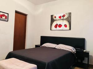 ein Schlafzimmer mit einem Bett und zwei Bildern an der Wand in der Unterkunft Casa Mayaka in La Paz