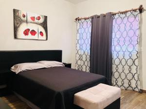 ein Schlafzimmer mit einem schwarzen Bett und einem Fenster in der Unterkunft Casa Mayaka in La Paz