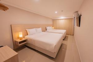 a hotel room with two beds and a lamp at Alcaré Rooms Cartagena in Cartagena de Indias