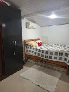 a small bedroom with a bed and a closet at Casas do Pescador in Maricá +10 photos