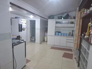 a kitchen with white cabinets and a refrigerator at Casas do Pescador in Maricá
