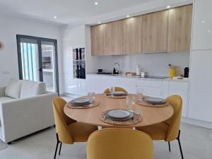 a kitchen and dining room with a table and chairs at Edifício da Vinha - Ocean Breeze Apartments in Armação de Pêra