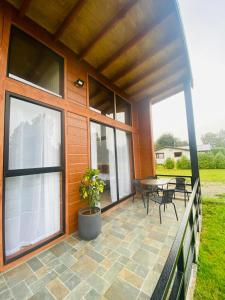 a house with a patio with a table and chairs at Refugio Matteo&Colo Sur de Chile in Panguipulli