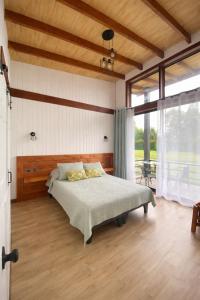 a bedroom with a bed and a large window at Refugio Matteo&Colo Sur de Chile in Panguipulli