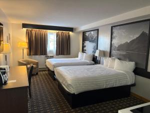 a hotel room with two beds and a desk at Super 8 by Wyndham Valemount in Valemount