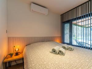 a bedroom with a bed with towels on it at Aperol Spritz in Zutendaal