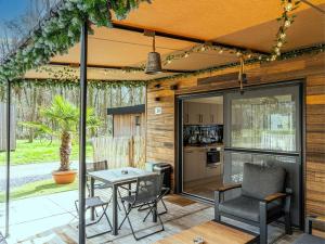 a patio with a table and chairs and a kitchen at Aperol Spritz in Zutendaal