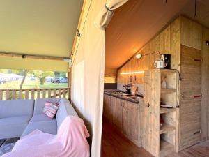 a kitchen and a couch in a tiny house at De Mier in Hulshorst