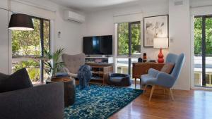 a living room with a couch and a tv at Kingfisher Loft in Daylesford