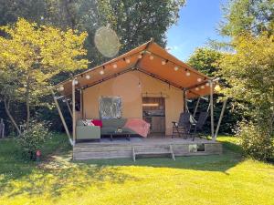 a gazebo with a couch and chairs in a backyard at de Krekel in Hulshorst