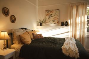 a bedroom with a bed and a window at Whimsy Cottage, Beachside retreat, Outdoor bath in Kingston Beach