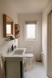 a bathroom with a toilet and a sink and a window at Whimsy Cottage, Beachside retreat, Outdoor bath in Kingston Beach +22 photos
