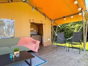 a tent with two chairs and a couch and a table at de Krekel in Hulshorst