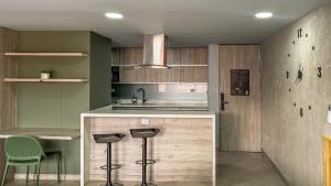 a kitchen with a counter and stools in it at Edificio Atalanta en el corazón de Medellín in Medellín +44 photos
