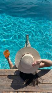 a woman in a hat sitting in a swimming pool at Cozy 1 bedroom in Punta Cana