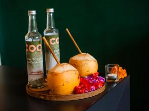 a table with two coconuts and two bottles of alcohol at Villa Sun Soul - Brand New 2bed Villa w Rice Field View in Ubud +46 photos
