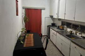 a kitchen with a table and a red curtain at Habitacion Privada, Single Room in Paysandú +7 photos
