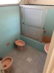 a bathroom with two pink toilets and a shower at Habitacion Privada, Single Room in Paysandú