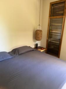 a bedroom with a blue bed with a window at Mango Soul in El Zonte