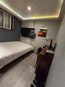 a bedroom with a bed and a desk with a computer at a 모텔 in Seoul