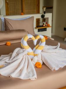 a pair of towels and a towel snake on a bed at Villa Sun Soul - Brand New 2bed Villa w Rice Field View in Ubud
