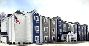 a large building with an american flag in front of it at Microtel Inn & Suites by Wyndham Springfield in Springfield