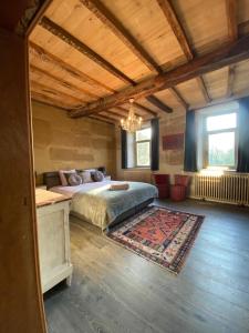 a large bedroom with a bed and a rug at Gîte La Cure in Noduwez