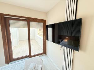 a room with a large window and a television on a wall at La suite N4-elegant suite near lido beach in Alghero +48 photos