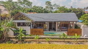 a house with a black roof and a pool at Villa Sun Soul - Brand New 2bed Villa w Rice Field View in Ubud