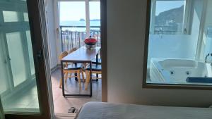 a room with a table and a bath tub and a bed at Geoje Haneul Ari Pension in Geoje