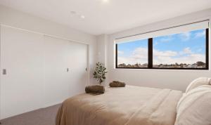 a bedroom with a large window and a bed at Waihi Beach Oasis - Apartment B1 in Waihi Beach