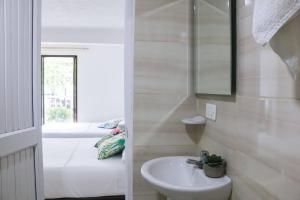 a bathroom with a sink and a mirror and a tub at Hospedaje s o s in Cali