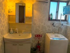 a bathroom with a sink and a toilet and a mirror at 温泉郡宿 in Toon +32 photos