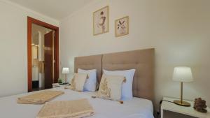 a bedroom with a bed with two towels on it at Baleal Beach Stay in Baleal