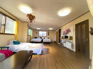 a hospital room with two beds and a table at 温泉郡宿 in Toon