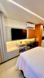 a bedroom with a bed and a tv on a wall at Flat com acesso rápido as praias e o melhor do turismo local in João Pessoa
