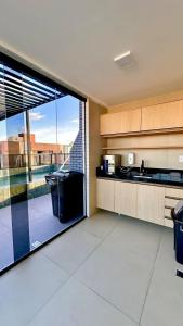 a kitchen with a large sliding glass door to a balcony at Flat com acesso rápido as praias e o melhor do turismo local in João Pessoa