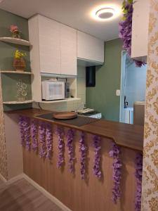 a kitchen with a counter with purple flowers on it at Flat com Vista Teatro Amazonas in Manaus