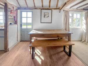 a wooden table in a room with a kitchen at Prospect Cottage in Wittersham +12 photos