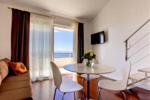 een woonkamer met een tafel en stoelen en een raam bij Apartments Lianto in Drasnice