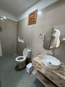 a bathroom with a toilet and a sink at Casa aconchego do pontal in Fortim