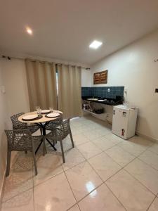 a dining room with a table and chairs and a kitchen at Casa aconchego do pontal in Fortim +1 photo