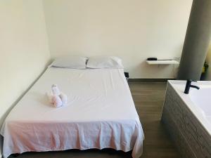 a stuffed animal sitting on a bed in a room at Hotel sahara in Medellín
