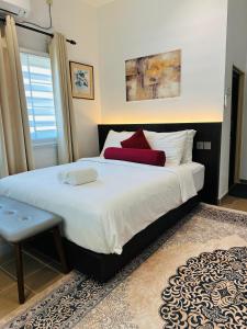 a bedroom with a large bed with red pillows at Rooma Kichi Private Pool in Pantai Cenang