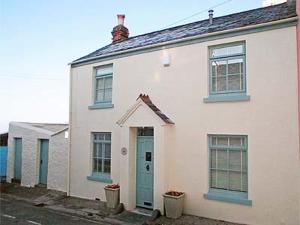 a white house with a blue door and windows at Kingsley Cottage in Instow