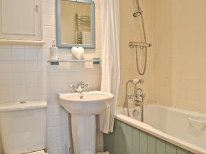 a bathroom with a sink and a toilet and a bath tub at Kingsley Cottage in Instow