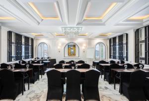a banquet hall with tables and chairs in a room with windows at Swiss-Belexpress Palu in Palu
