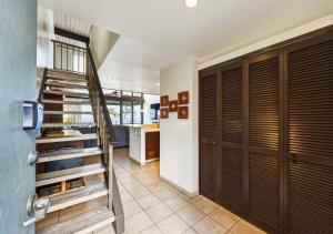 a hallway with wooden doors and a staircase in a kitchen at Spacious 2BR Oceanfront Loft - Unit C17 condo in Lahaina