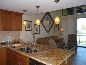 a kitchen with a sink and a living room at Peaceful Ocean-View 2BR Loft Escape - Unit C38 condo in Lahaina